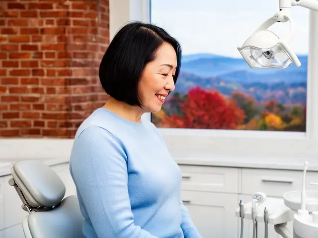 A dentist standing beside a dental chair.
